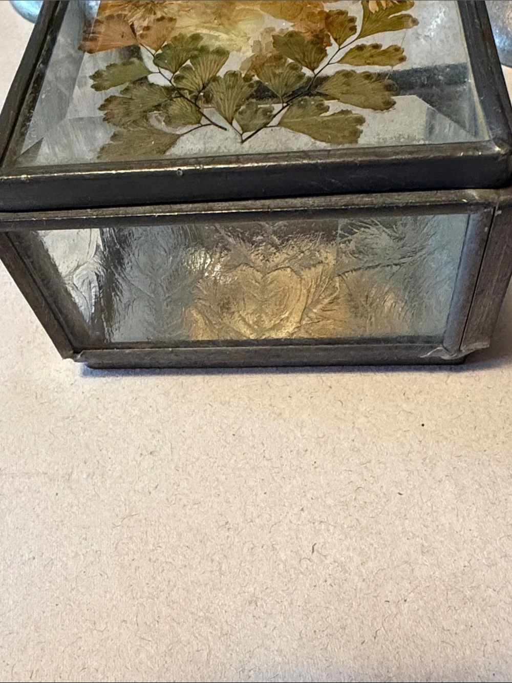 Vintage trinket box with metal edges and dried flowers on top. Mirror bottom.